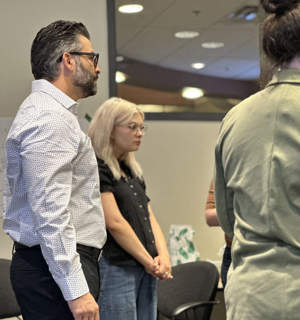 A facilitator listens closely as a team member speaks from her land