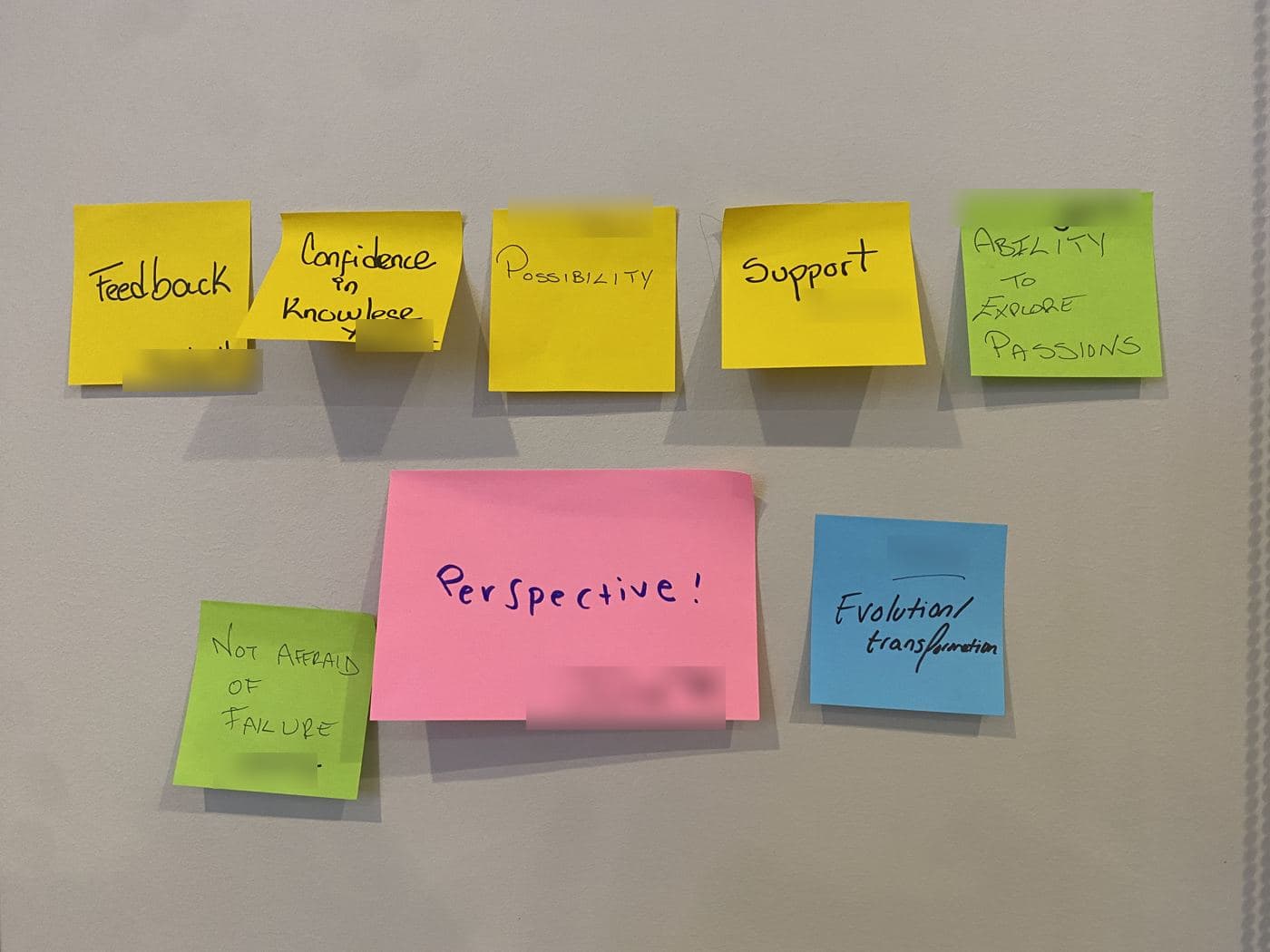 Sticky notes on a wall reading Feedback, Confidence in knowledge, Possibility, Support, Ability to explore passions, Perspective, Not afraid of failure, and Evolution and transformation