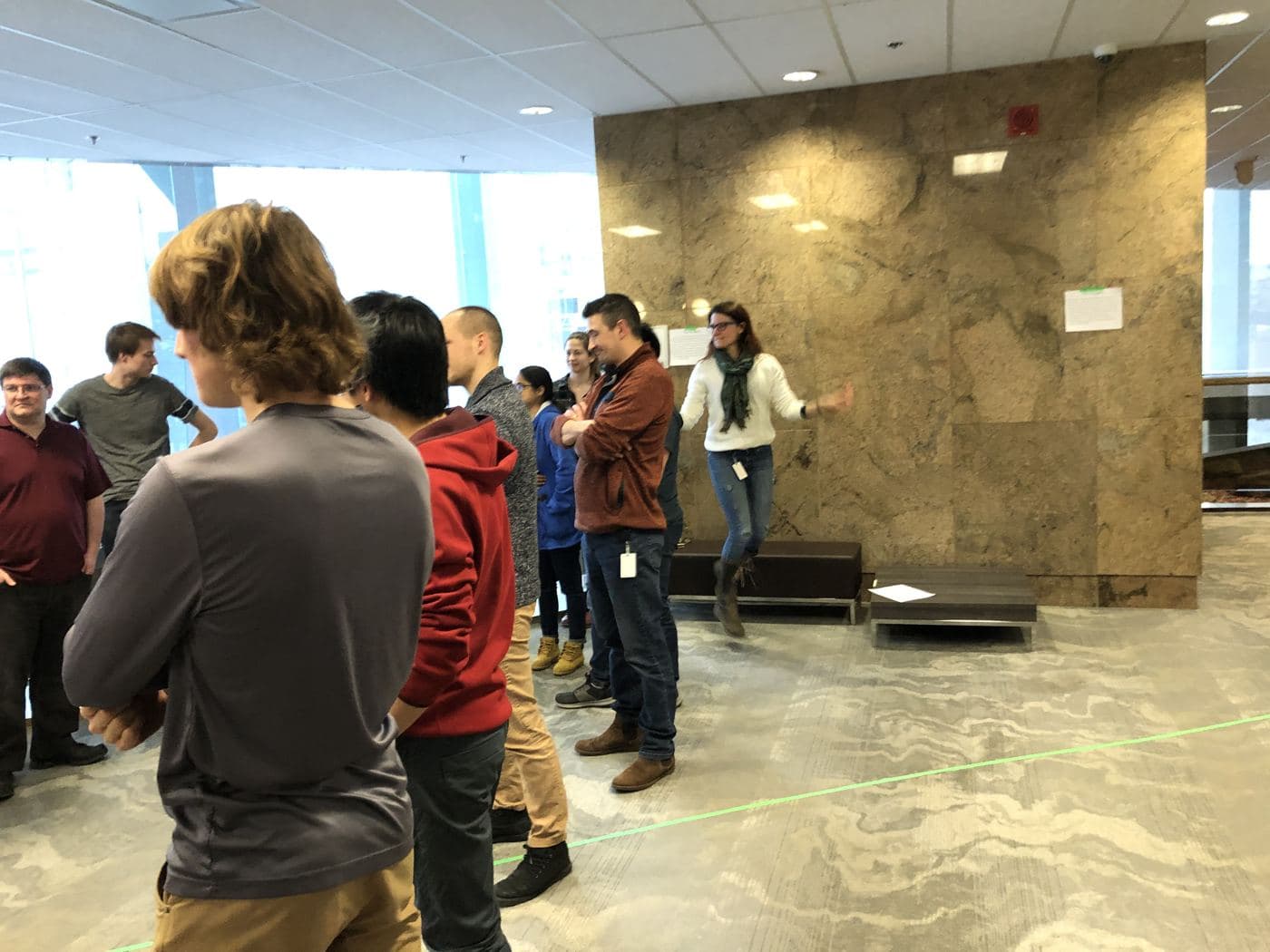 A participant stretches her arms wide as her group shows its silent motion to the room