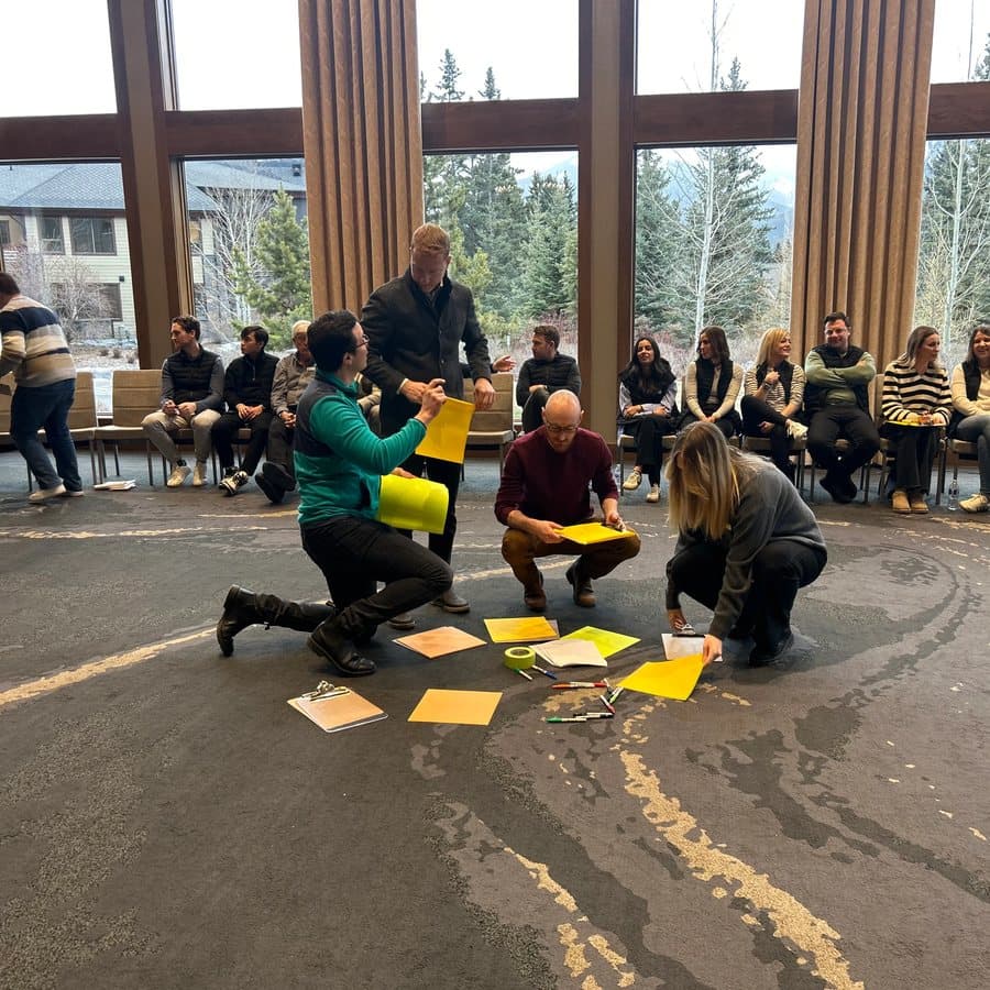 Participants kneel in the center of a circle of chairs to write and post their discussion topics