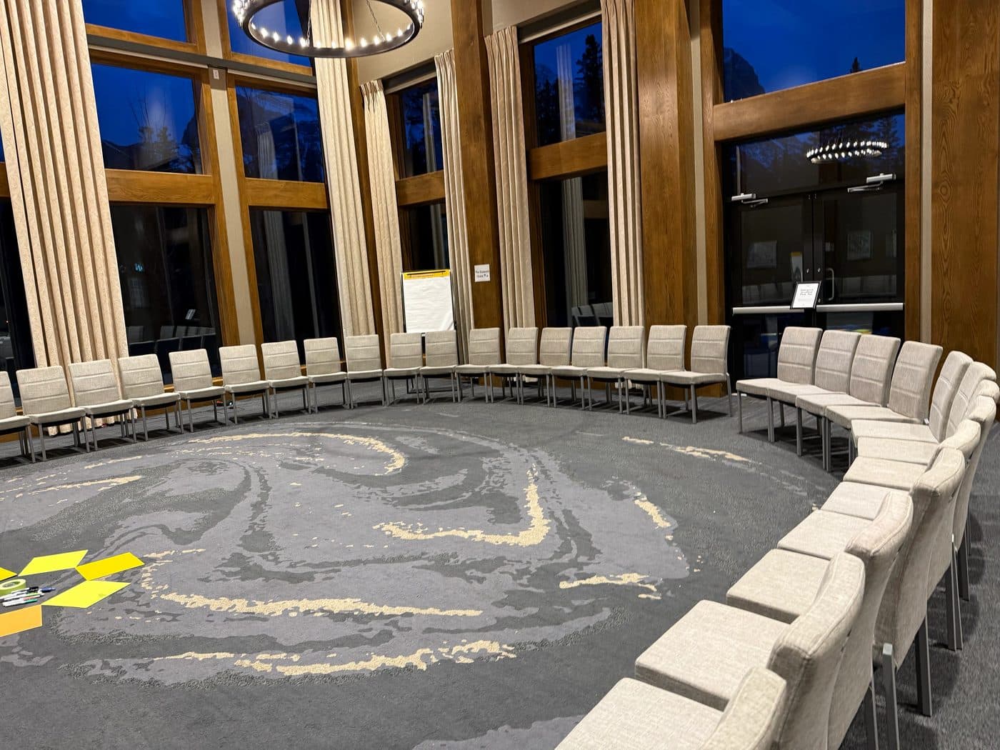 An empty circle of chairs set up in a lodge meeting room before an Open Space session
