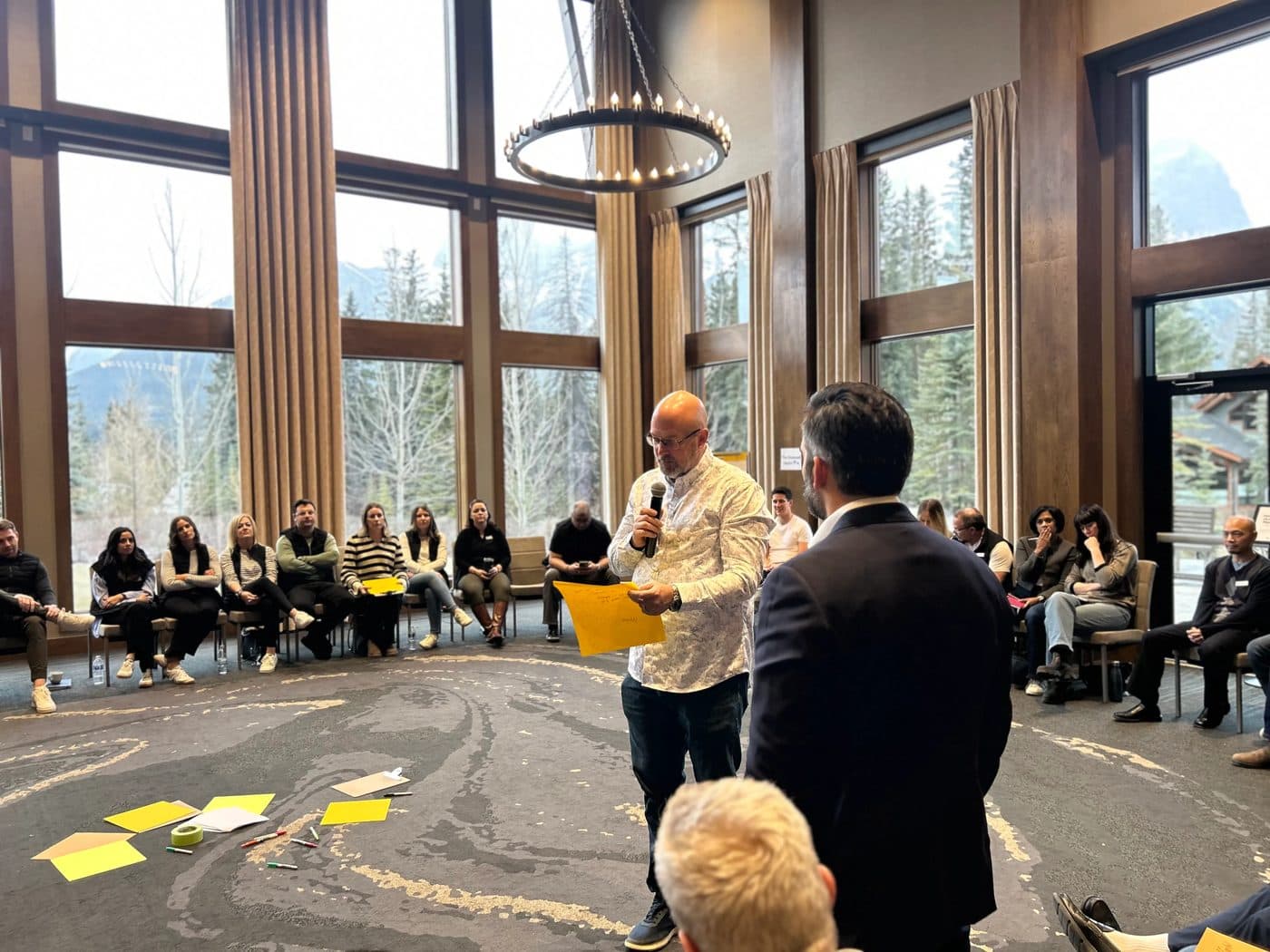A participant announces a discussion topic to the circle using a microphone